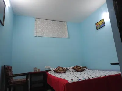 a blue room with a bed and a window at Shanthi Villa in Coonoor