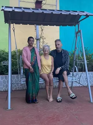 a group of three people sitting on a bench at Shanthi Villa in Coonoor