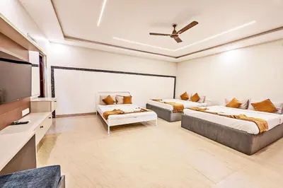 a bedroom with two beds and a flat screen tv at Kaadgal Resort in Kanakapura