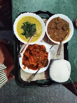 a tray with three bowls of food on a table at Bhuvanam homestay in Kalpetta