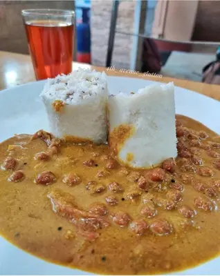 a plate of food with cheese and nuts on a table at Bhuvanam homestay in Kalpetta