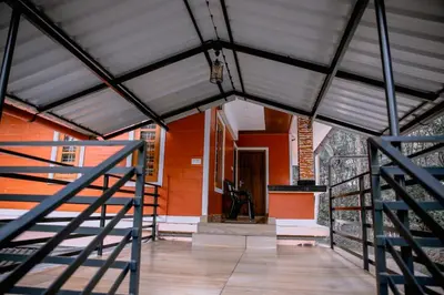 a room with a staircase and a red wall at Bhuvanam homestay in Kalpetta