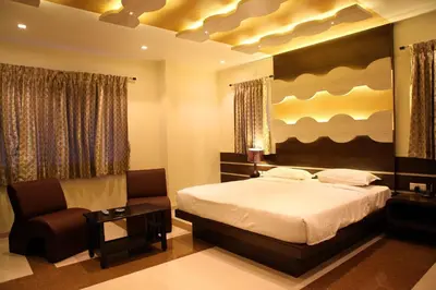 a bedroom with a bed and a chair at SBS Grand in Coimbatore