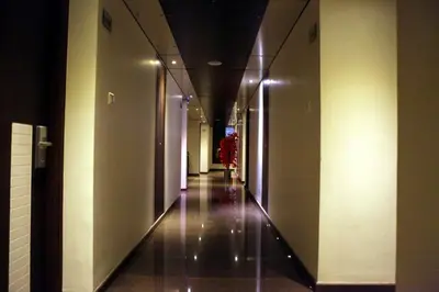 a hallway in a building with lights on the walls at SBS Grand in Coimbatore
