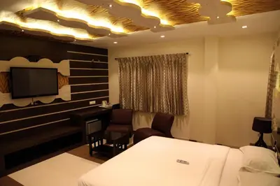 a hotel room with a bed and a desk and a tv at SBS Grand in Coimbatore