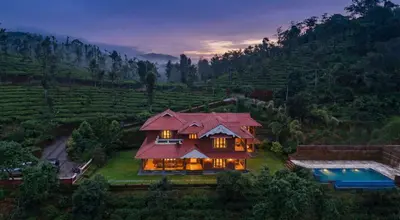 a house with a red roof and a swimming pool at StayVista at Regal Retreat 5BR - Big Villa with Pvt Pool in Wayanad
