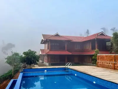 a house with a swimming pool in front of it at StayVista at Regal Retreat 5BR - Big Villa with Pvt Pool in Wayanad