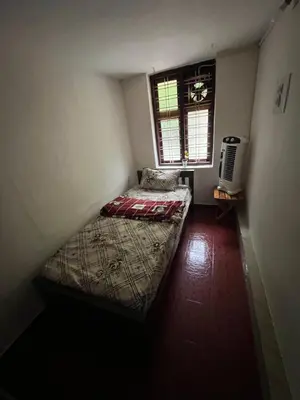 a small bedroom with a bed and a window at Dragster Homes in Kizhake Chālakudi