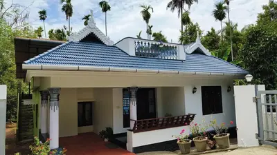 a small house with a blue roof at Dragster Homes in Kizhake Chālakudi