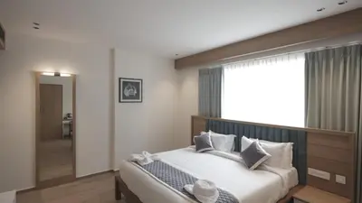 a bedroom with a large bed and a large window at RITZ AVENUE LUXURY HOTEL in Mahe