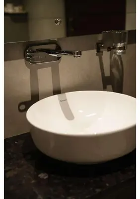 a white sink in a bathroom with a faucet at RITZ AVENUE LUXURY HOTEL in Mahe