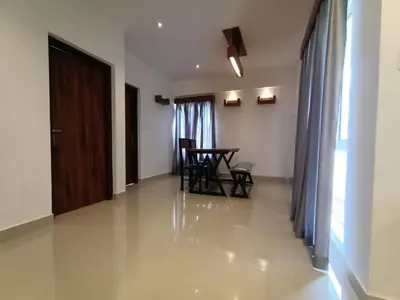 a living room with a dining room table and chairs at Spicy Nest Resort in Pinangode