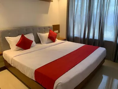 a bedroom with a large bed with red and white pillows at Spicy Nest Resort in Pinangode