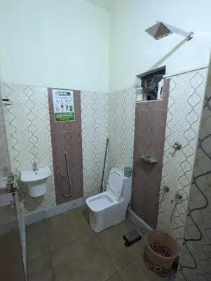 a bathroom with a toilet and a sink at San Unik Homestay in Nilambūr
