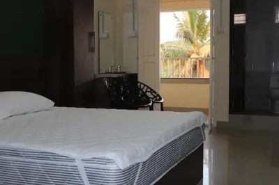 a bedroom with a white bed and a window at San Unik Homestay in Nilambūr