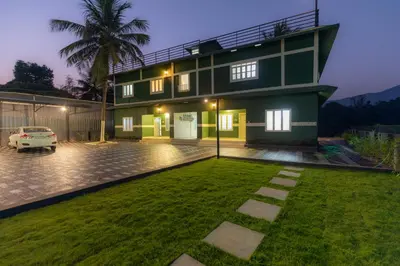 a house with a lawn in front of it at San Unik Homestay in Nilambūr