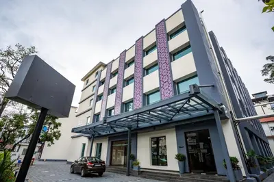 a building with a sign in front of it at Lilac Hotel Guruvayur in Guruvāyūr