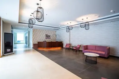a lobby with a couch and a table and a tv at Lilac Hotel Guruvayur in Guruvāyūr