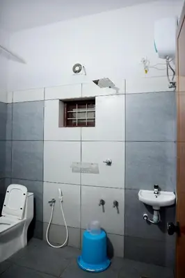 a small bathroom with a toilet and a sink at PADAVAYAL GREENS in Attappādi