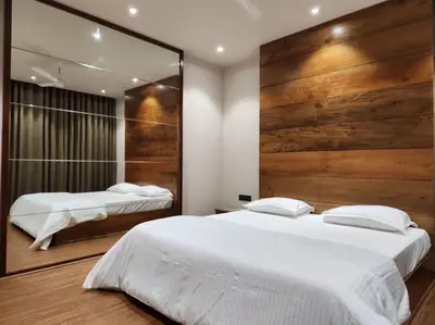 a bedroom with two beds and a mirror at Gulzar 2BHK Service Apartment, kannur in Kannur