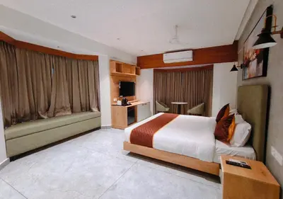 a hotel room with a bed and a couch at Mayo Suites in Palakkad
