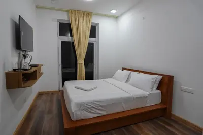a bedroom with a bed with a television and a window at Richfields in Ooty