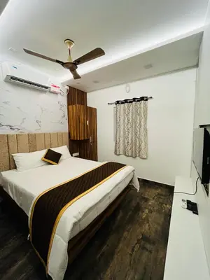 a bedroom with a bed and a ceiling fan at The Tendoinn in Pollāchi