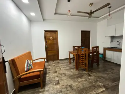 a kitchen and dining room with a table and chairs at The Tendoinn in Pollāchi