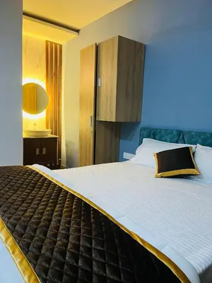 a bedroom with a large bed with a yellow pillow at The Tendoinn in Pollāchi