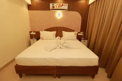 a bedroom with a bed with two towels on it at Liwa Tower Hotel & Business Center in Kunnamkulam