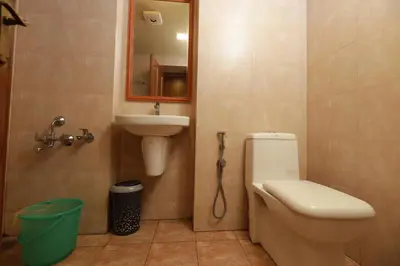a bathroom with a toilet and a sink and a mirror at Liwa Tower Hotel & Business Center in Kunnamkulam