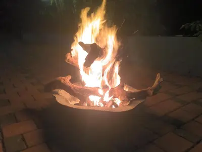 a fire burns in a fire pit at night at Nature Greens Cottage in Madikeri