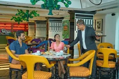 three people sitting at a table in a restaurant at Noah Sky Suites in Cochin