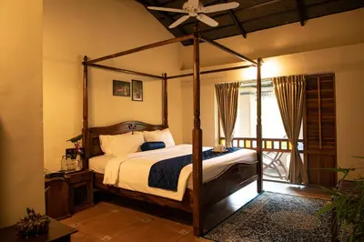a bedroom with a canopy bed and a balcony at Akshaya Bungalow by Sparsa in Sethumadai