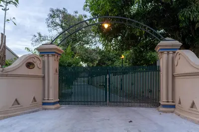 an entrance to a gate with an iron fence at Akshaya Bungalow by Sparsa in Sethumadai