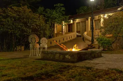 a fire pit in front of a house at night at Akshaya Bungalow by Sparsa in Sethumadai