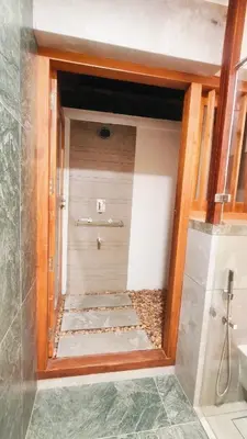 a bathroom with a walk in shower and a walk in shower at Meleppura Heritage Homestay in Chāvakkād