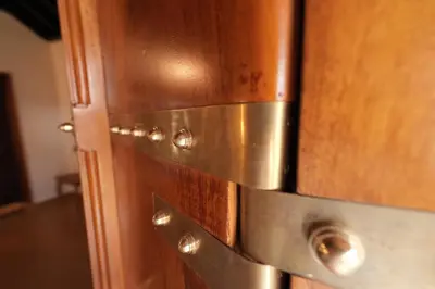 a close up of a wooden cabinet with metal pulls at Meleppura Heritage Homestay in Chāvakkād