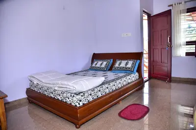 a bed in a room with a red door at Madhuvana Homestay Coorg in Madikeri