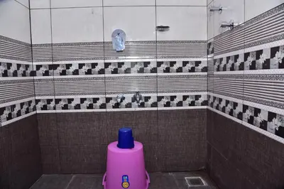 a pink bottle is sitting in a bathroom at Madhuvana Homestay Coorg in Madikeri