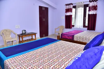 a bedroom with two beds and a table and chairs at Madhuvana Homestay Coorg in Madikeri