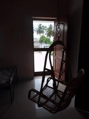 a chair sitting in a room with a window at Aathira's 2 Bedroom house @ Heart of Coimbatore in Coimbatore