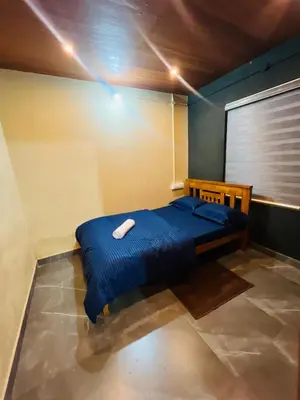 a bedroom with a blue bed with a white object on it at Elora Resort Wayanad in Kalpetta