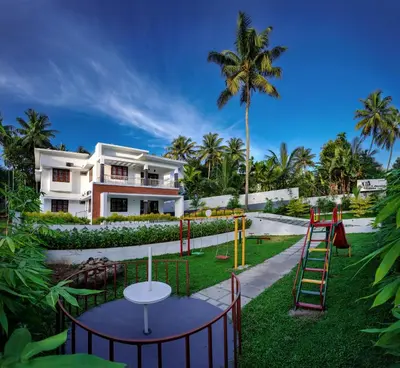 a playground in front of a house at The Vogue - Luxury Private Pool Villa , Athirappilly in Athirappilly
