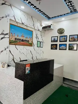 a room with a stone wall with a picture on the wall at ROSEPARK INN in Mysore