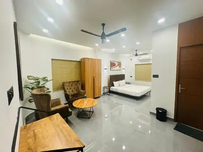 a living room with a couch and a table at ZAHIR RESIDENCY in Kondotti