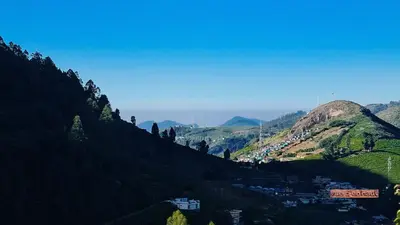 a view of a mountain with a town on a hill at Vue D'en Haut, Ooty,India in Ooty