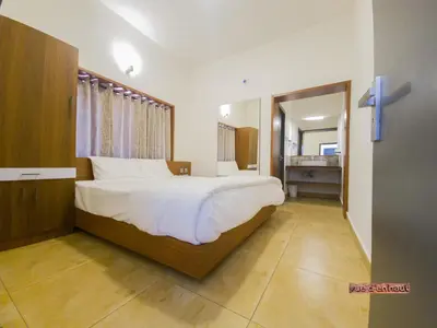 a bedroom with a large bed and a bathroom at Vue D'en Haut, Ooty,India in Ooty