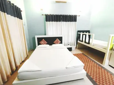 a bedroom with two beds and a crib at Dreamnest Residency in Kalpetta