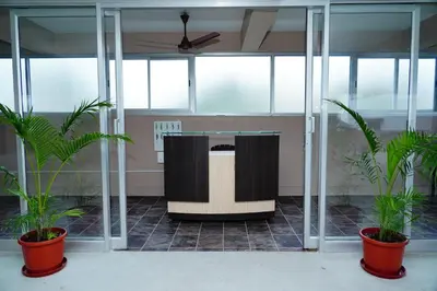 a lobby with two potted plants and a lectern at Meadow Comfort Stay in Coimbatore